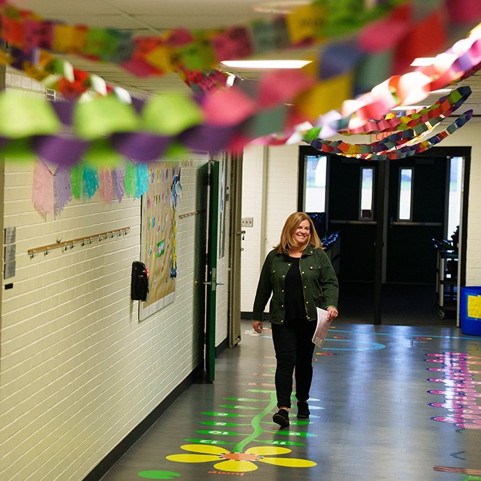 A teacher walking down the hall of a school