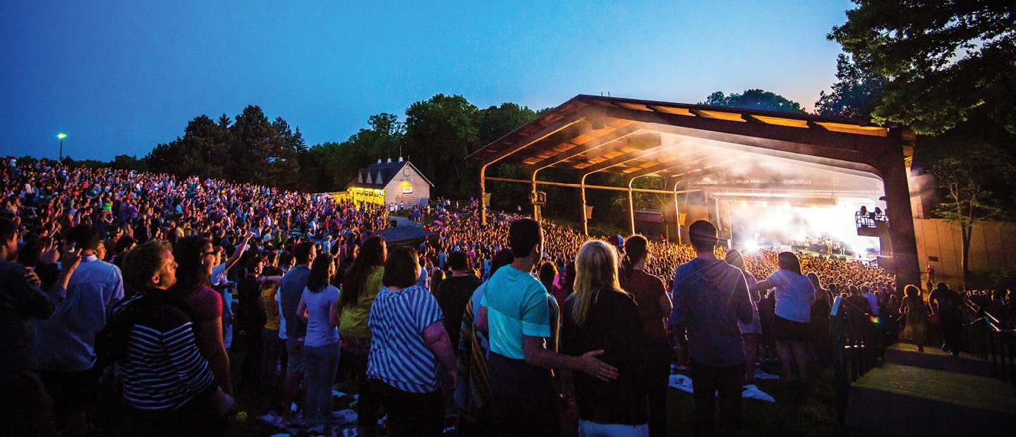 Large crowd on the lawn of Meadow Brook Music Festival, watching an outdoor concert.