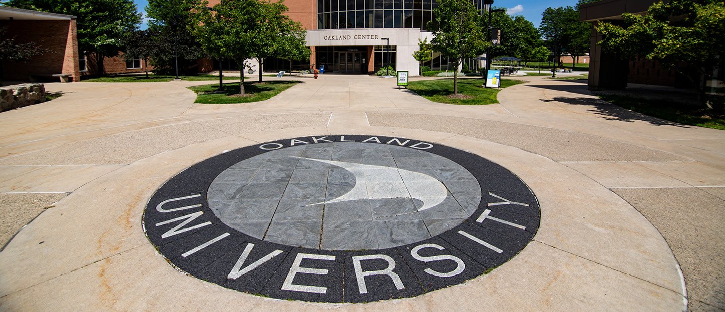 Oakland University sail symbol in the concrete outside the Oakland Center building.