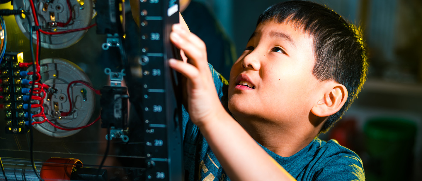 Young boy working on a piece of electrical equipment