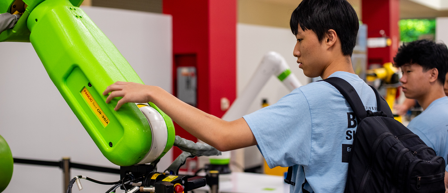 Students working with robotic machines in a lab.