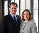 Craig and Ann Stinson posing together for a photo in front of a window.