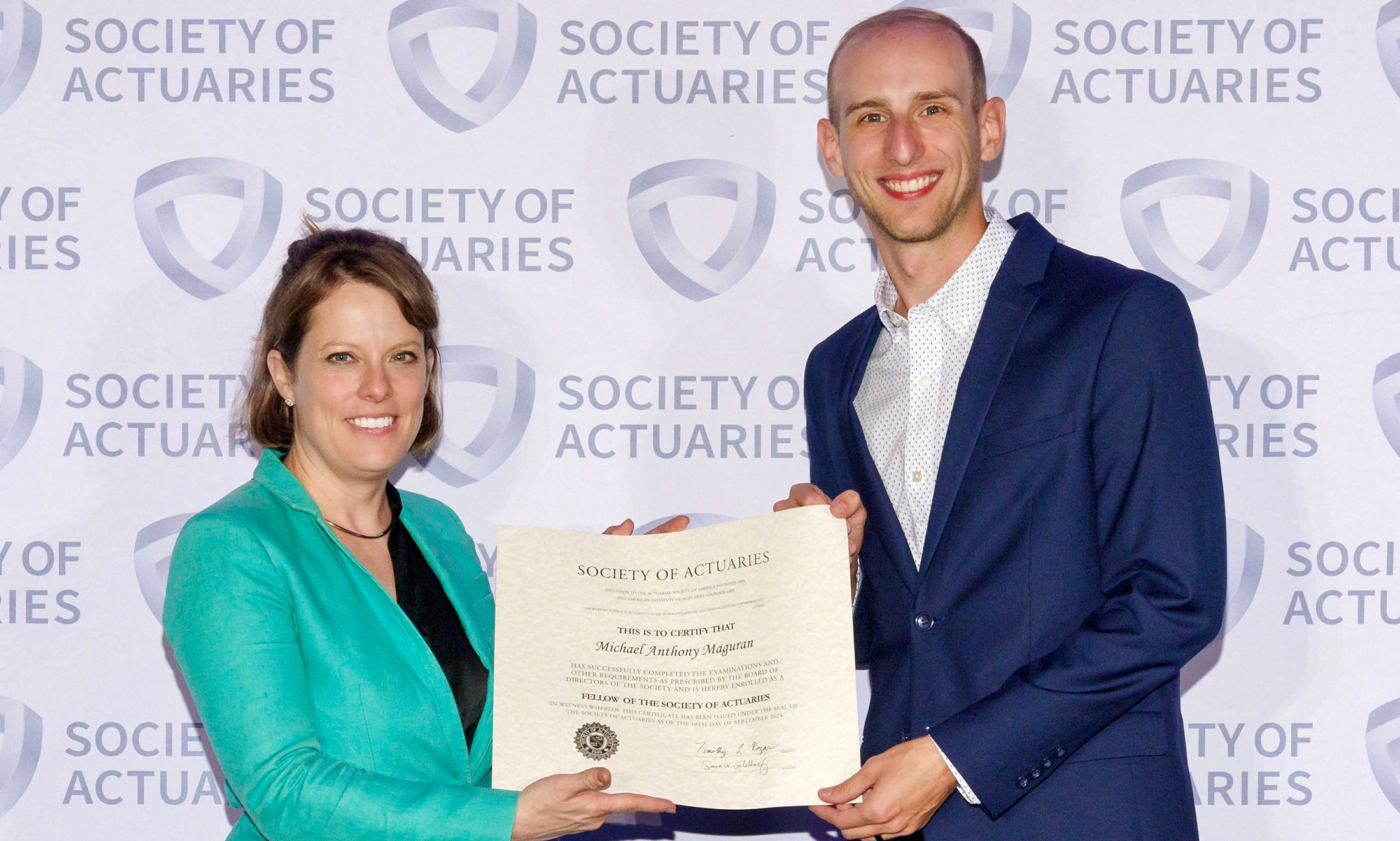 Michael Maguran (right) receives his certificate for becoming a Fellow of the Society of Actuaries (FSA).