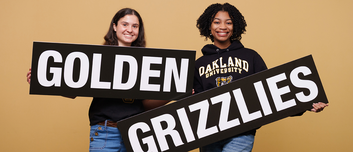 Black and Gold Giving Day Two students holding a sign that says