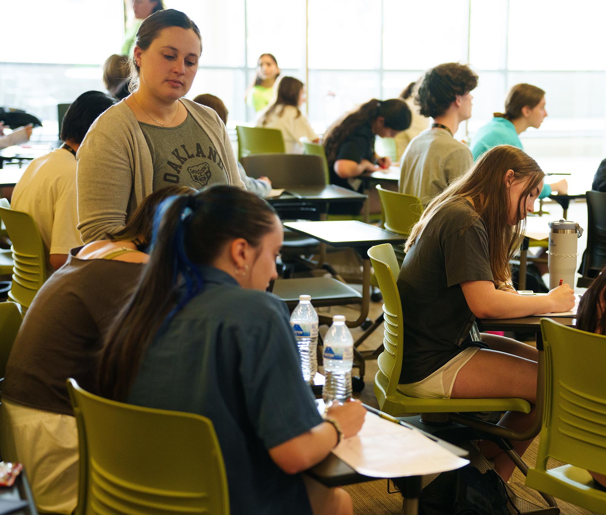 Group of people sitting at desks writing on paper