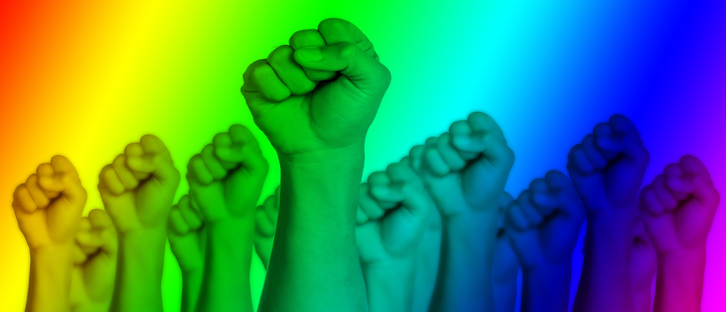 Many fists pumping up into the air with a rainbow overlay