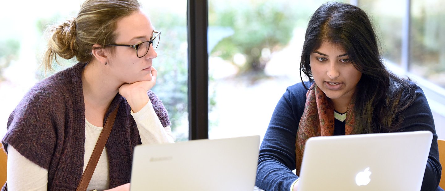 Request Information Banner two women seated behind open laptops
