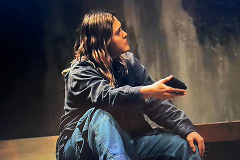 An actor sitting on a stage.
