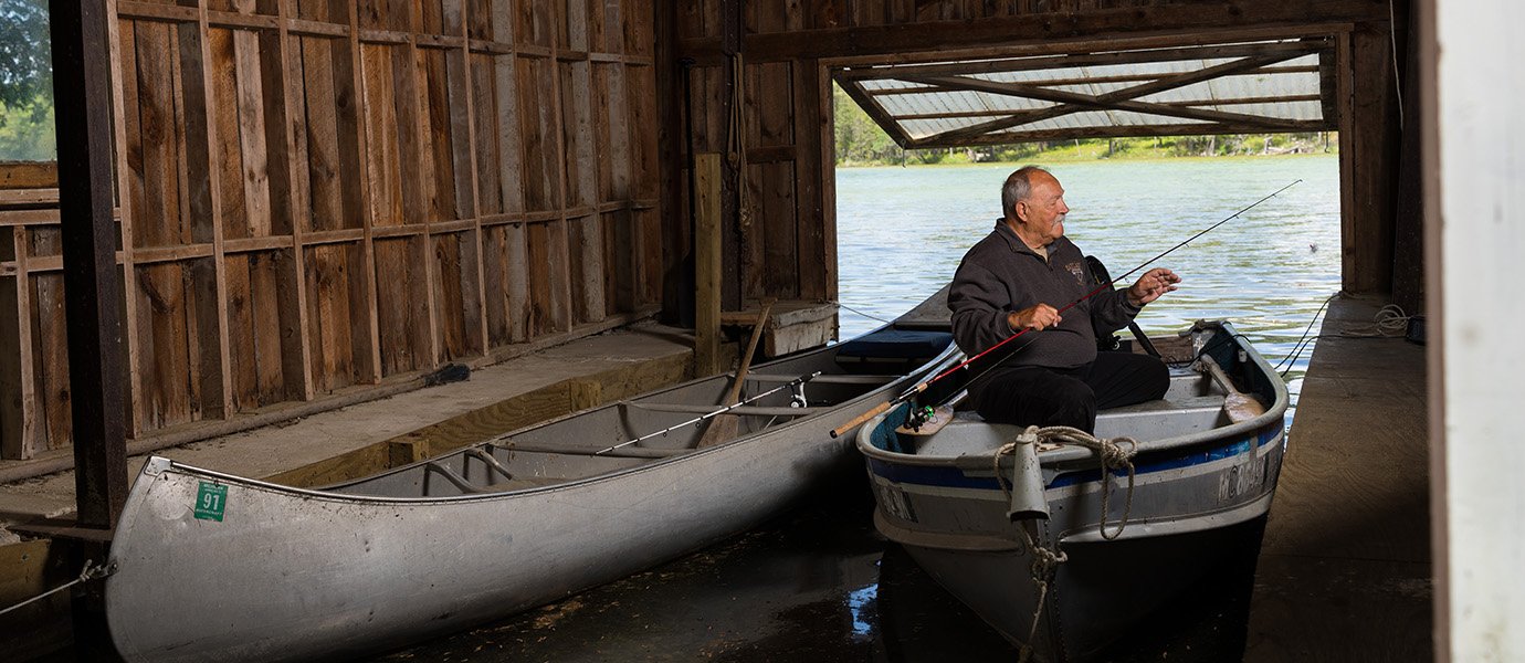 A man in a boat next to a canoe