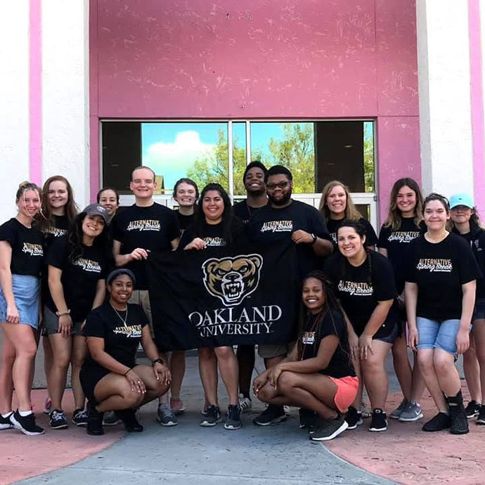 Group of students holding Oakland University flag