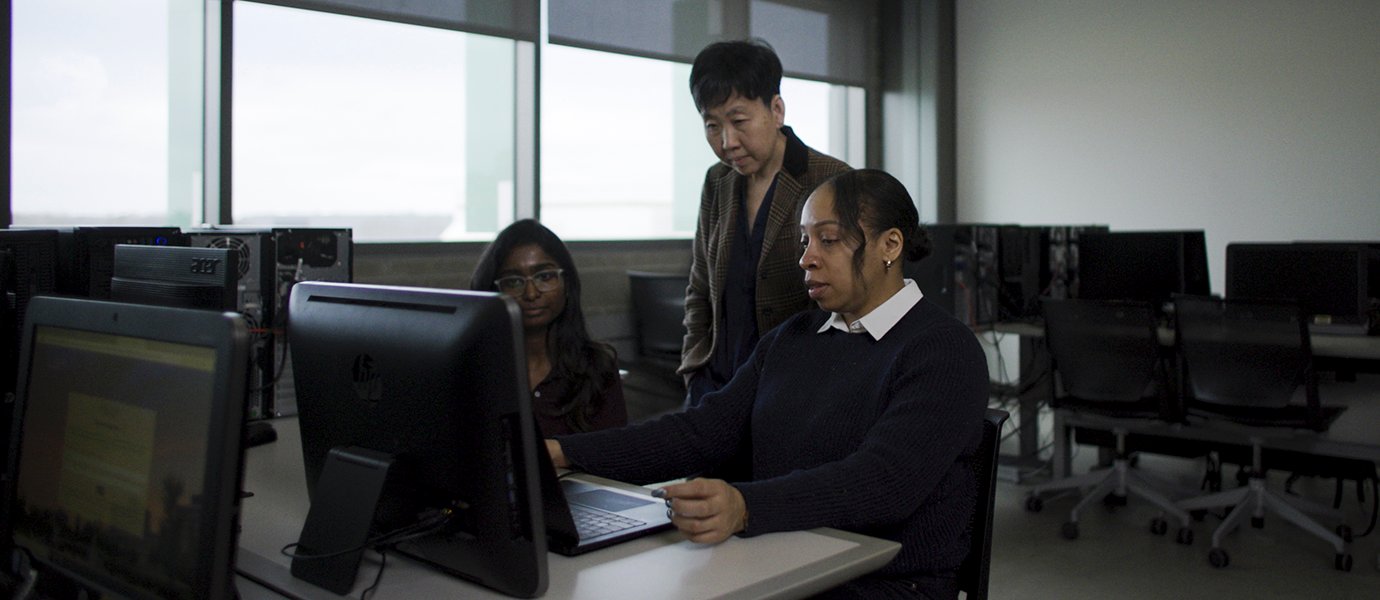 Woman working with students