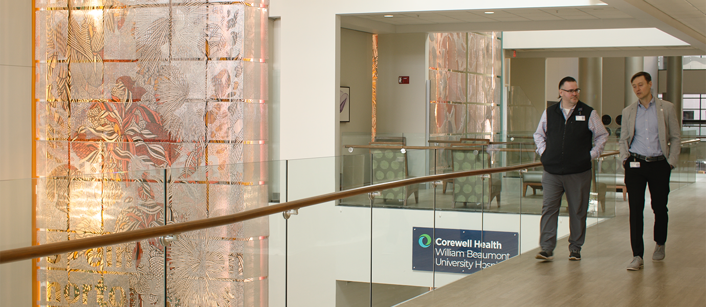 Two men walking down hallway in hospital