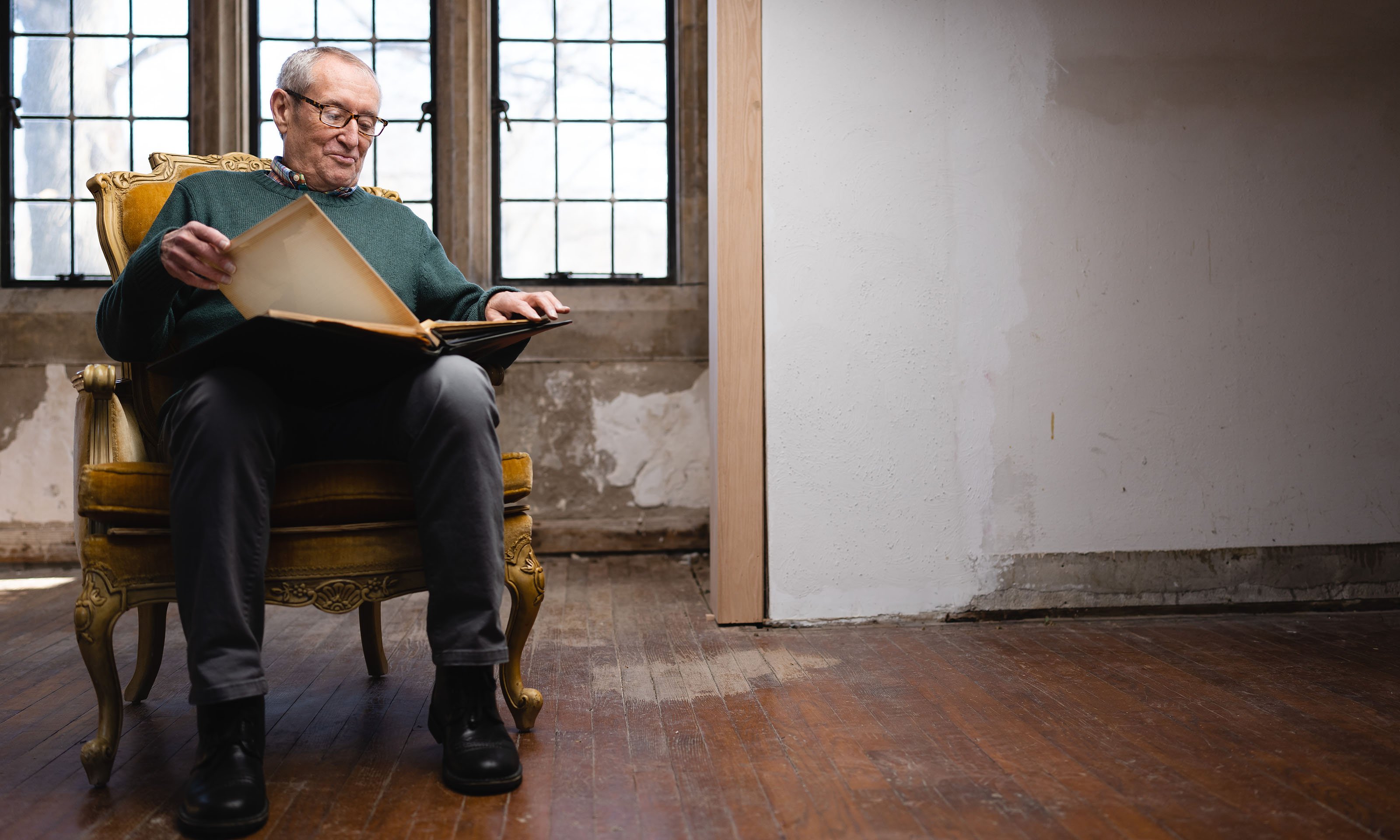 A man in a gold seat reading a book