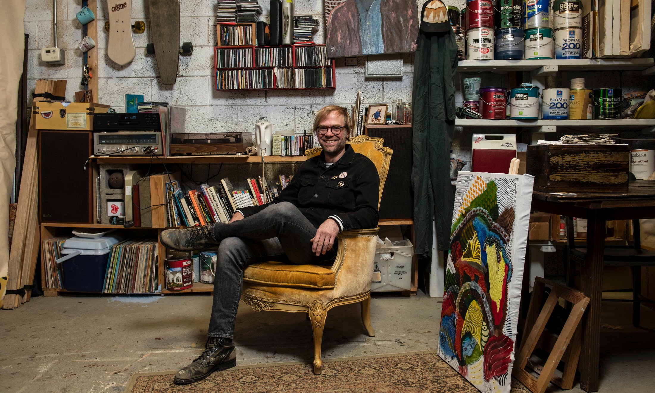 A man sitting in a gold seat in his art studio