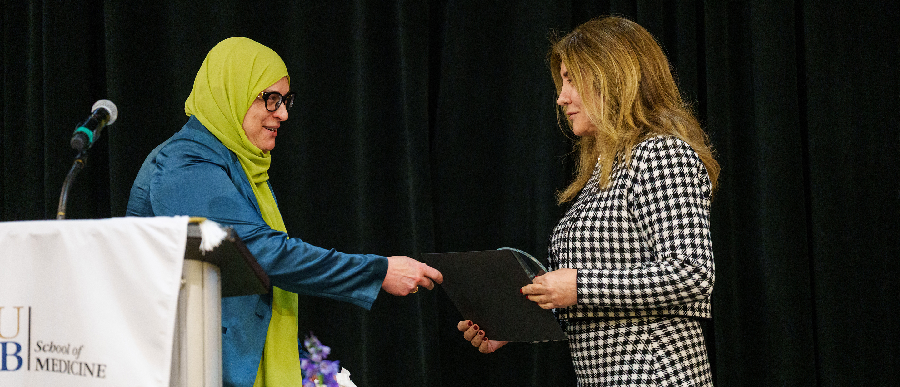 Faculty Recognition Banner An image of a faculty member handing an award to another faculty member