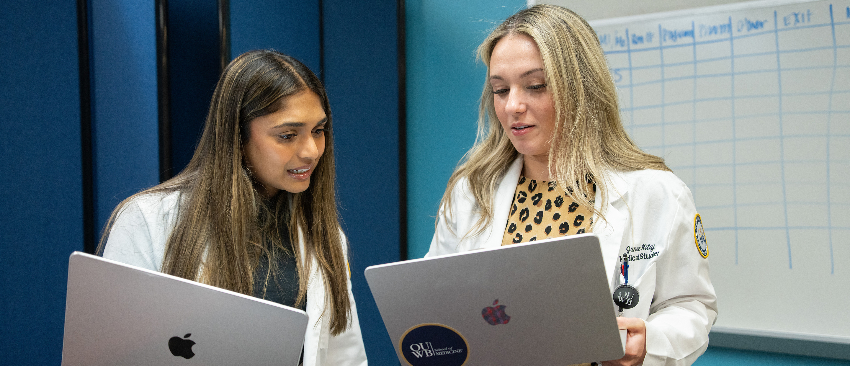 Technology Banner An image of two students with each holding a laptop