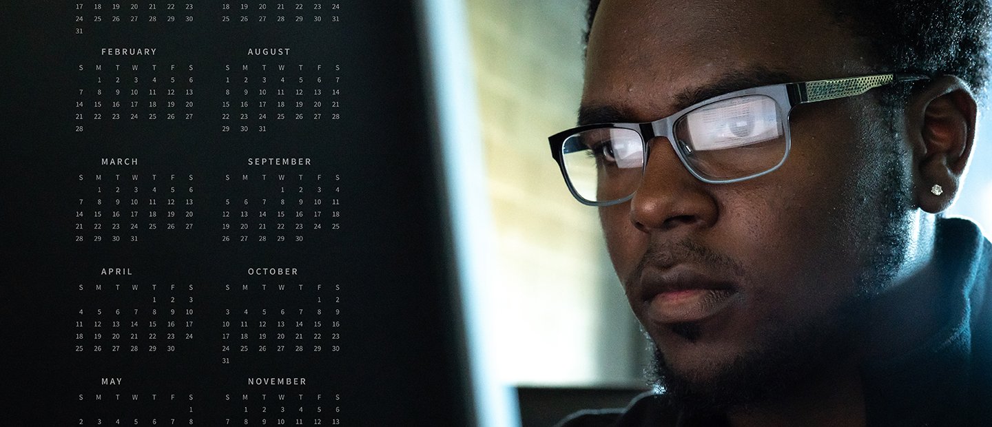 Man looking intensely at a screen with a few months of calenders on the left