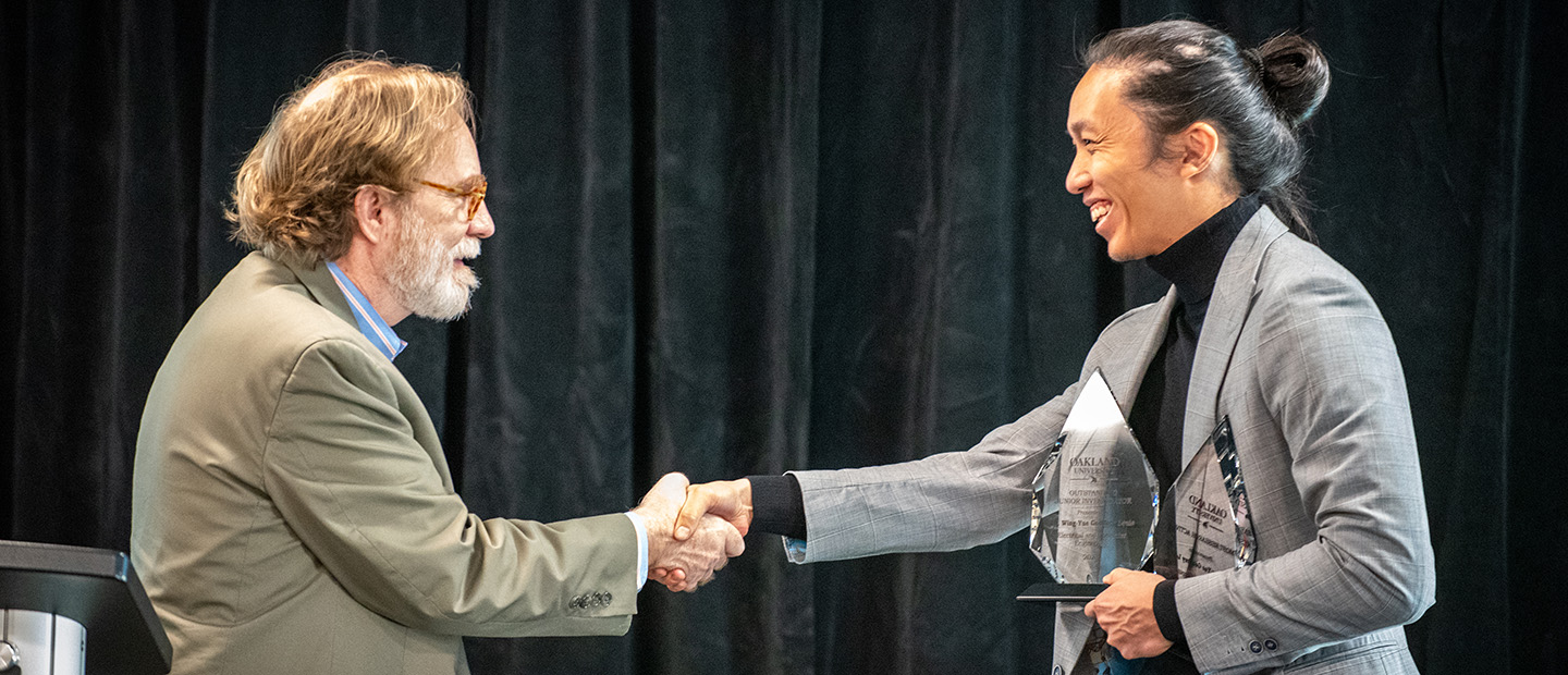 A man presenting an award to another person.