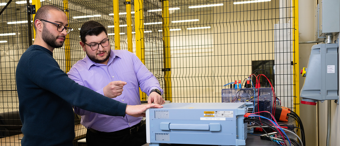 Two men working with electrical equipment