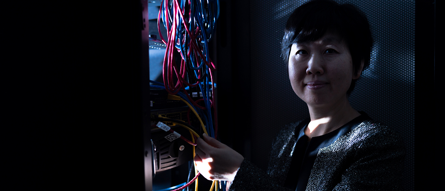 A woman holding the wires from a computer