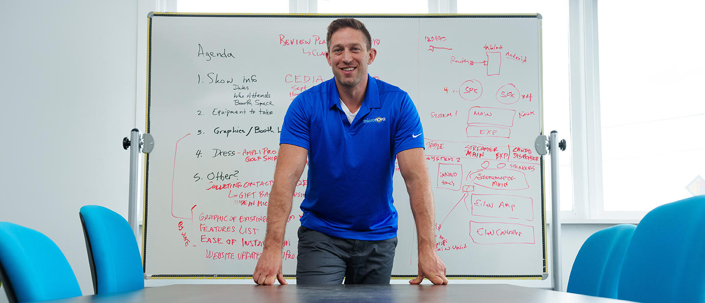 A man standing in front of a white board in a classroom