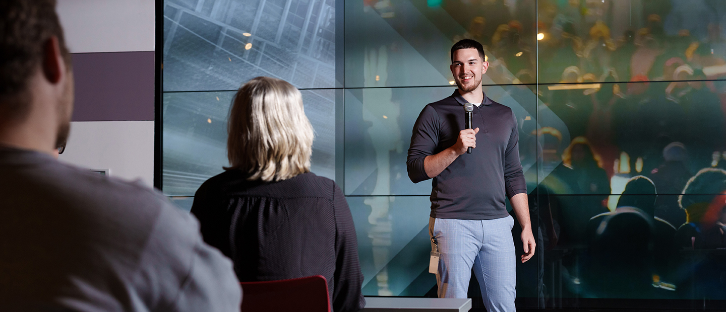 Career and Life Design for Employers A man holding a microphone, presenting