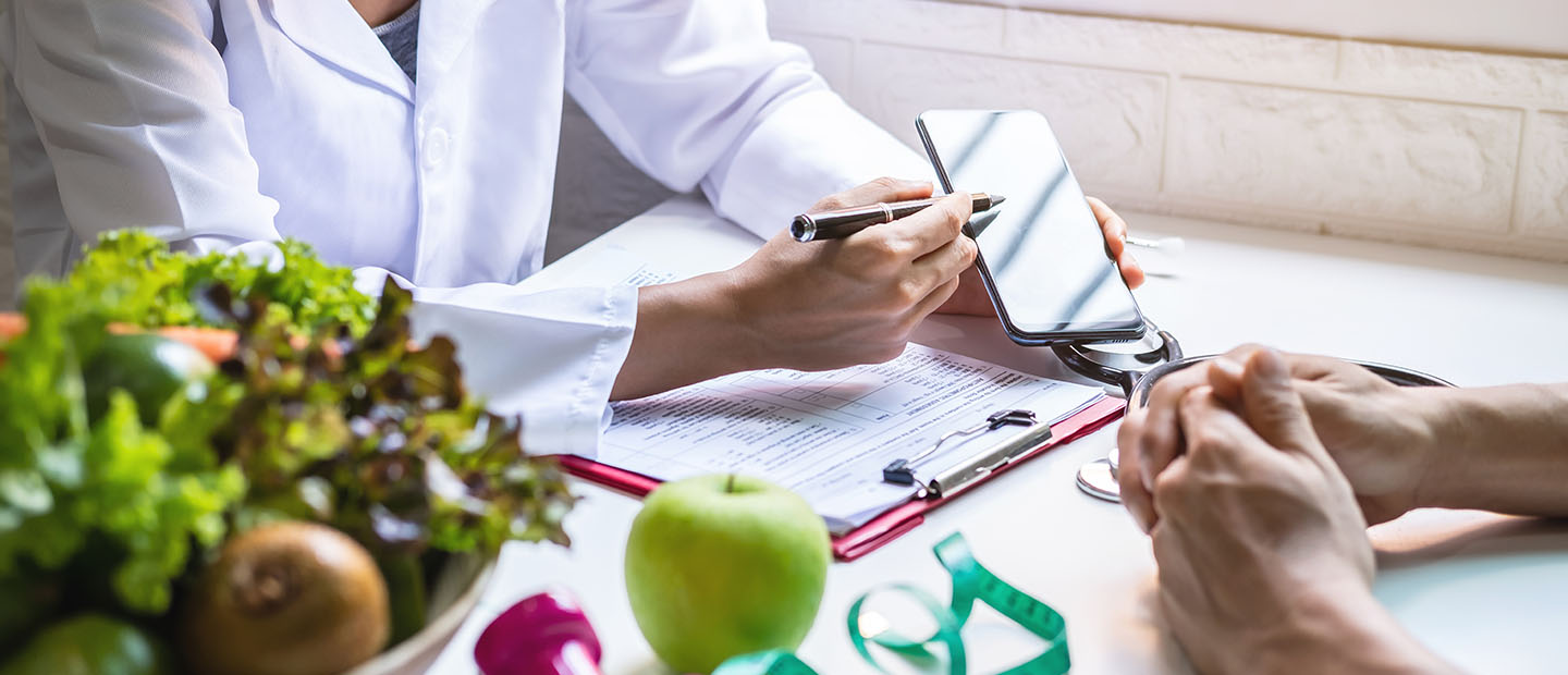 A dietitian showing a client information on a phone.