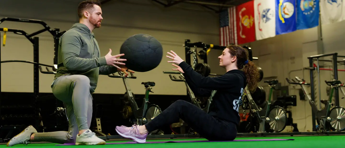 Two people performing partner core exercises.