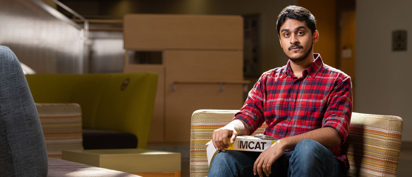 A man sitting in a chair, looking at the camera.