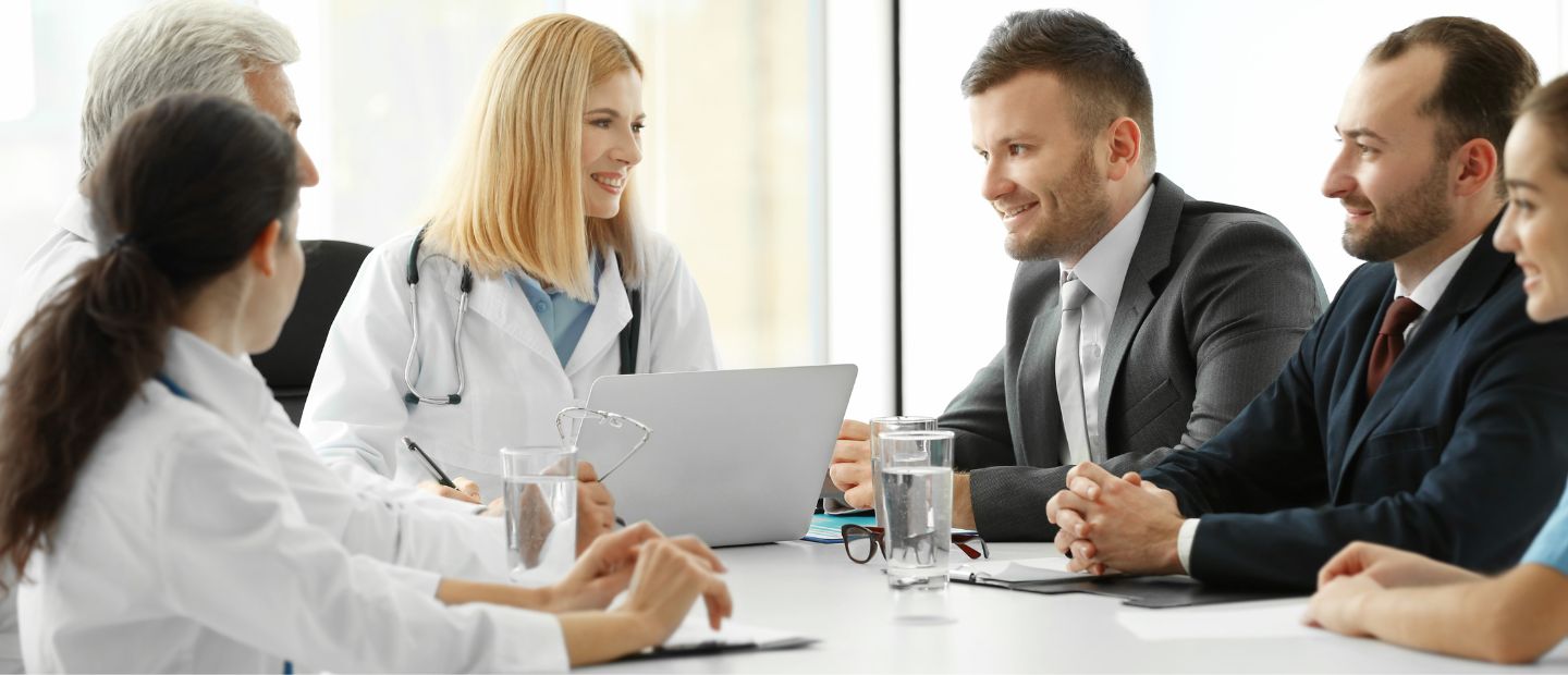 Healthcare professionals seated in a meeting room.