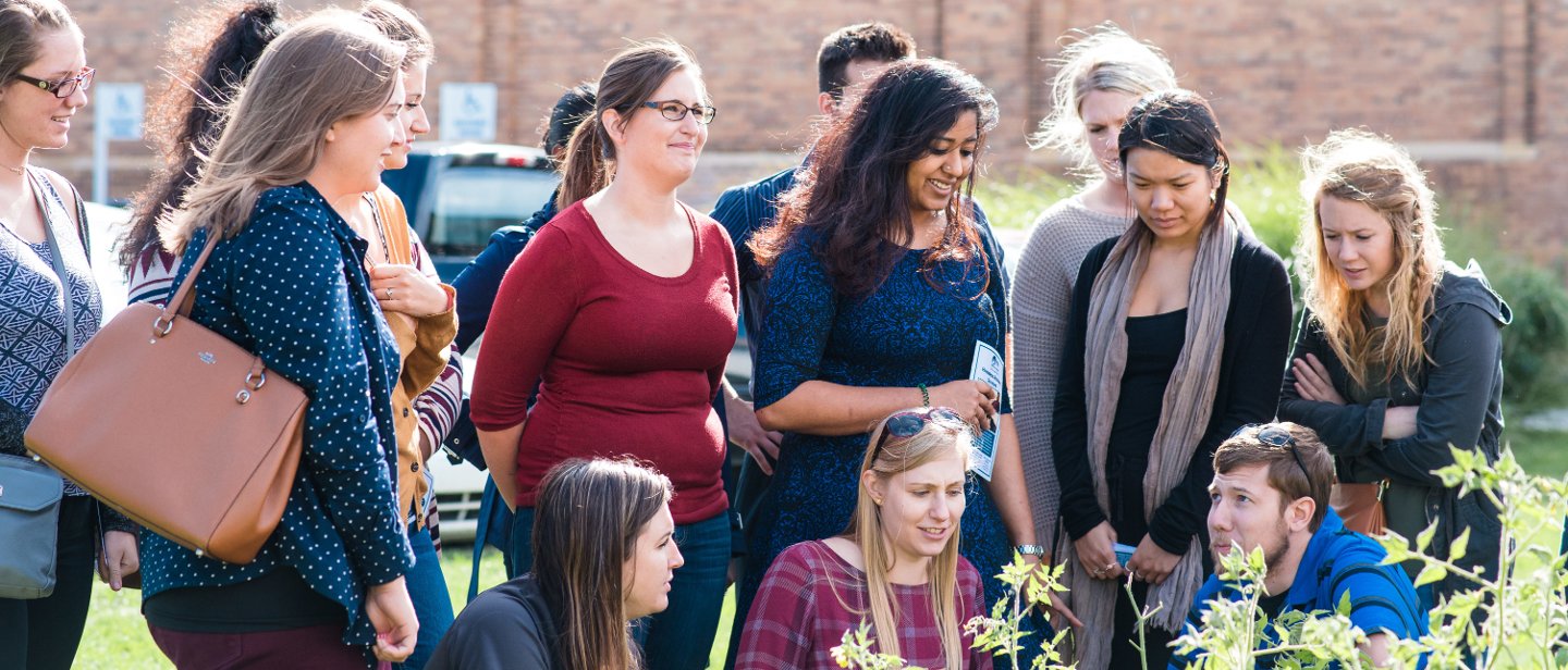 A group of students outside, standing or kneeling.