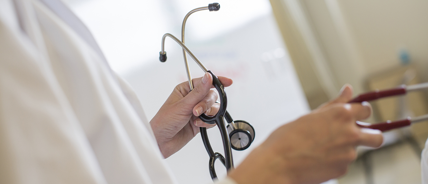 A person's hand holding a stethoscope.