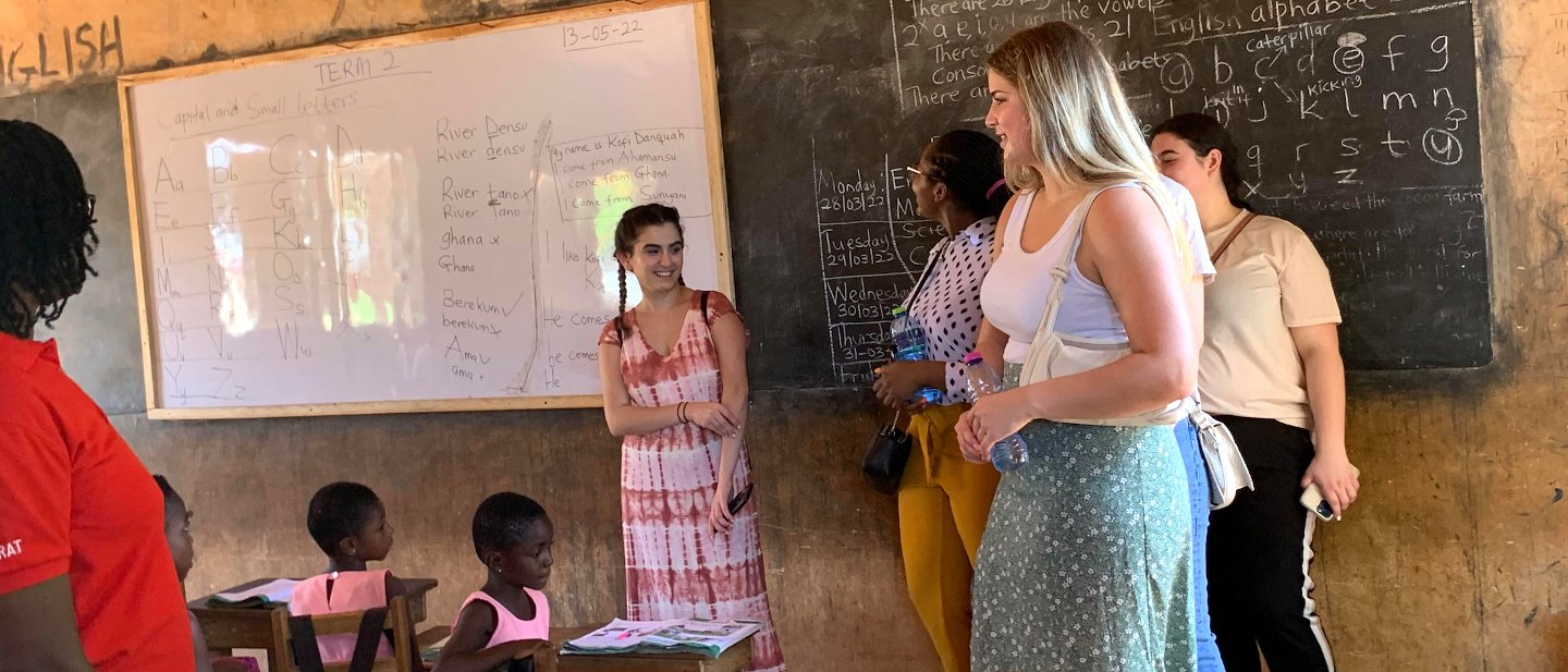 Students and children in a classroom.