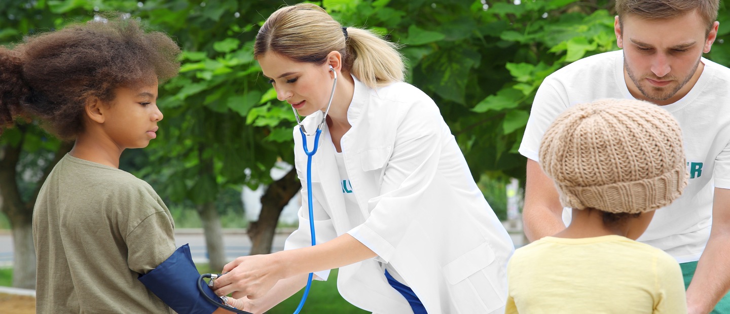 Medical professionals taking children's blood pressure