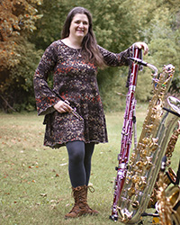 Stacey Jamison standing outside with instruments