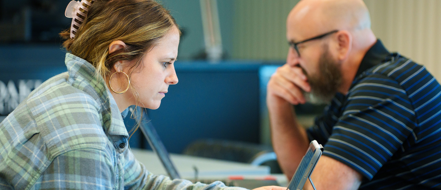 Two adult learners working on laptops