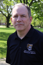 A professional headshot of Steve Szalay in a black Oakland University shirt.