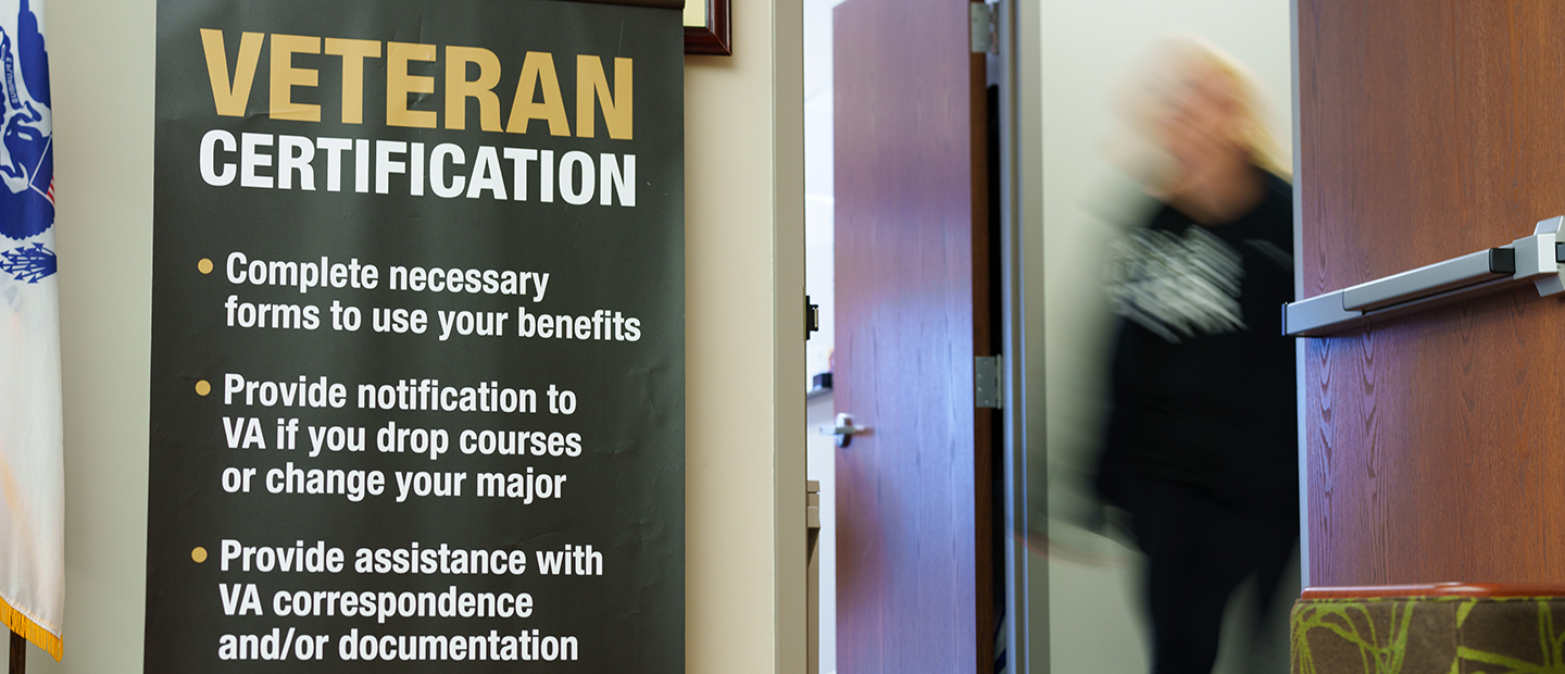 A woman walks near a banner that reads 