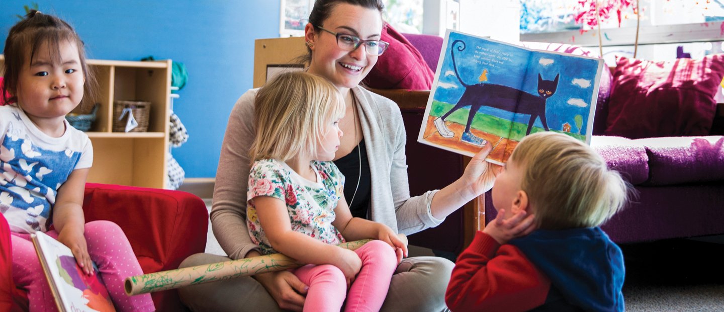 Teacher sitting with child in her lap