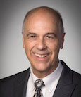 Headshot: Gentleman in suit and tie smiling at the camera.