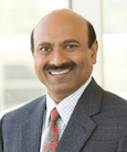 Headshot: Gentleman with mustache in suit smiling at the camera.