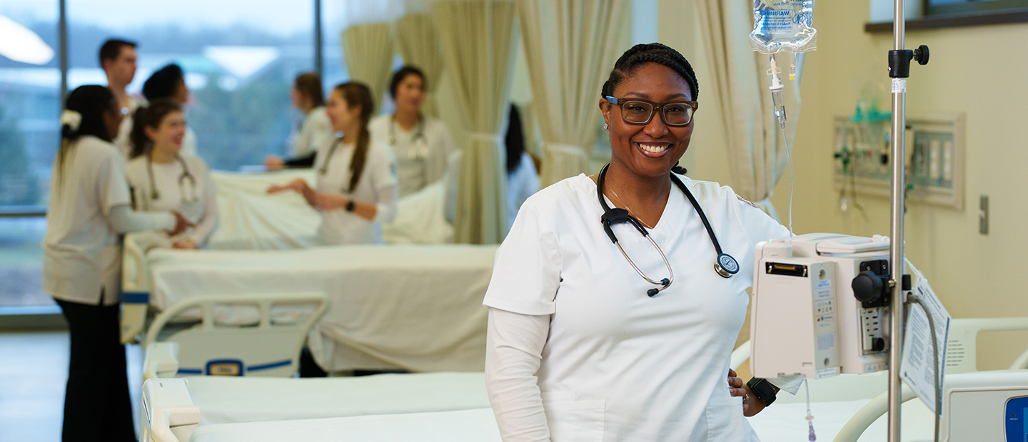 woman stadning in front of hospital bed smiling at camera