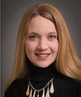 Headshot: woman in a black sweater smiling at the camera