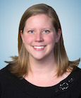 Headshot: Blonde woman in Black top smiling at the camera