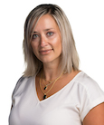 Headshot: Blonde woman in white short sleeve top smiling at camera