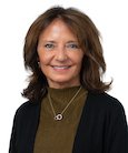 Headshot: Dark haired woman in green turtleneck with black jacket smiling at camera