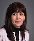 Headshot Dark haired woman in Black and white top smiling at the camera