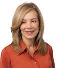 Headshot: Woman in coral top smiling at the camera