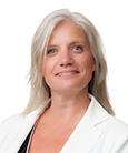 Headshot: Blonde Woman in dark top and white jacket smiling at the camera