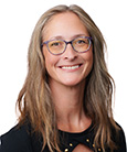 Blonde woman in a black shirt and glasses smiling at the camera. Academic Advisor